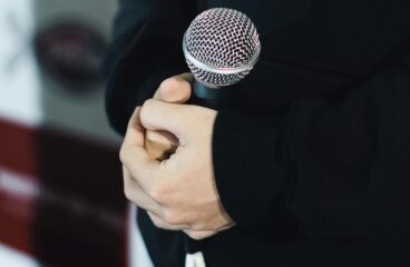 Close-up of hands clasping a microphone, ready for a speech or performance.