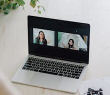 Laptop displaying a video call, arranged with musical notes and a ukulele.